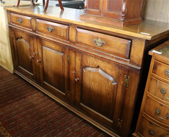 An 18th century style panelled oak cupboard